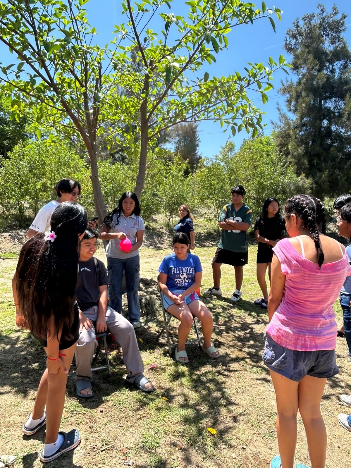Jóvenes reunidos bajo la palapa escuchando una charla