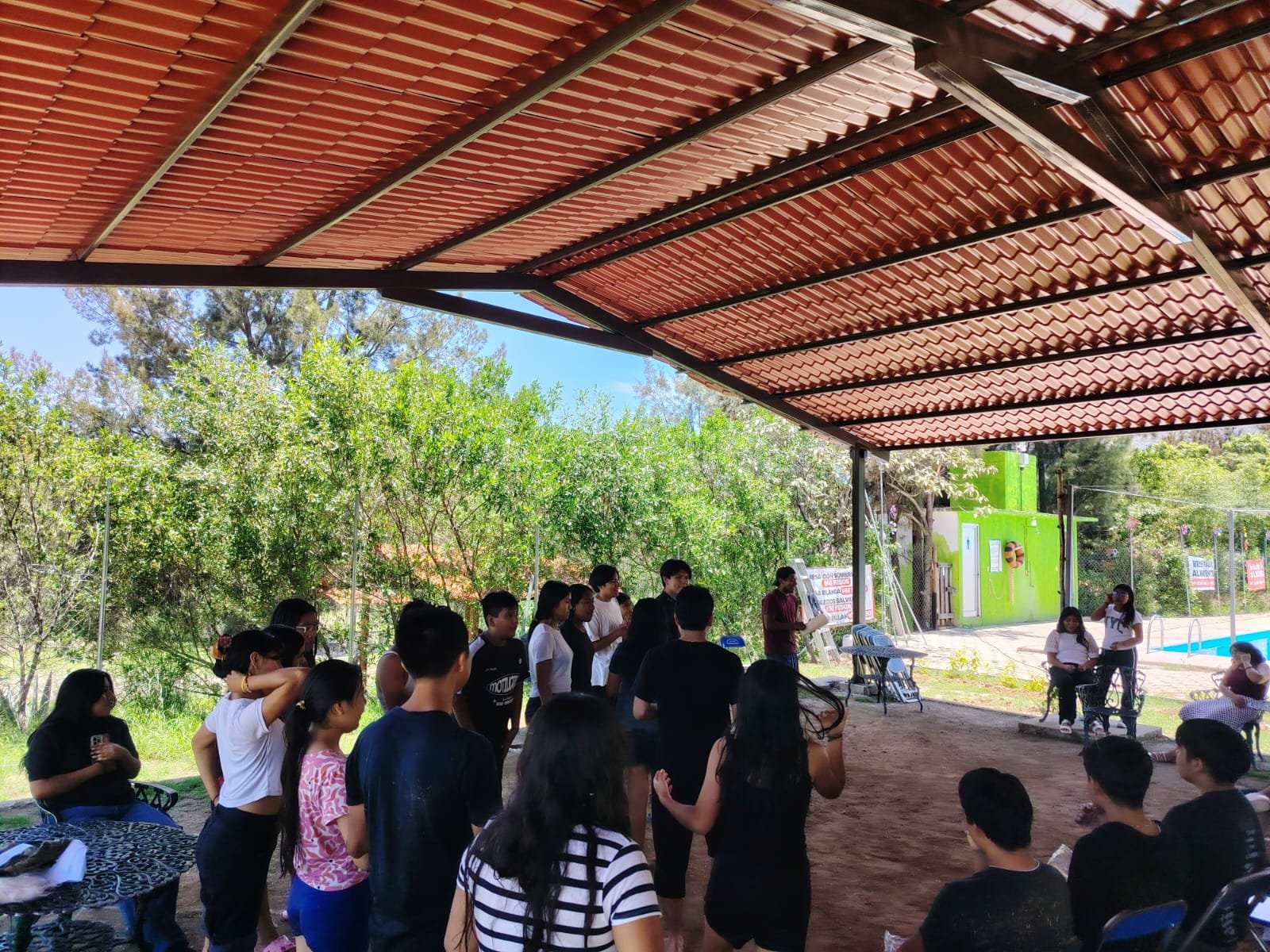 Juego en equipo recostados en el pasto sosteniendo un recipiente